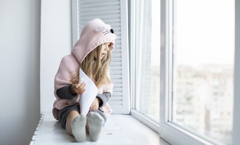 Young girl looking out of window